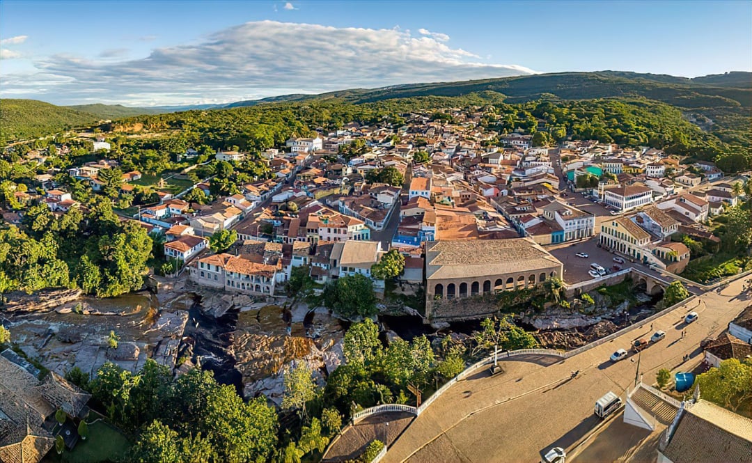 Vista aérea de Lençóis mostrando casas coloniais do século XIX, pontes de pedra e o rio sinuoso que corta a cidade.