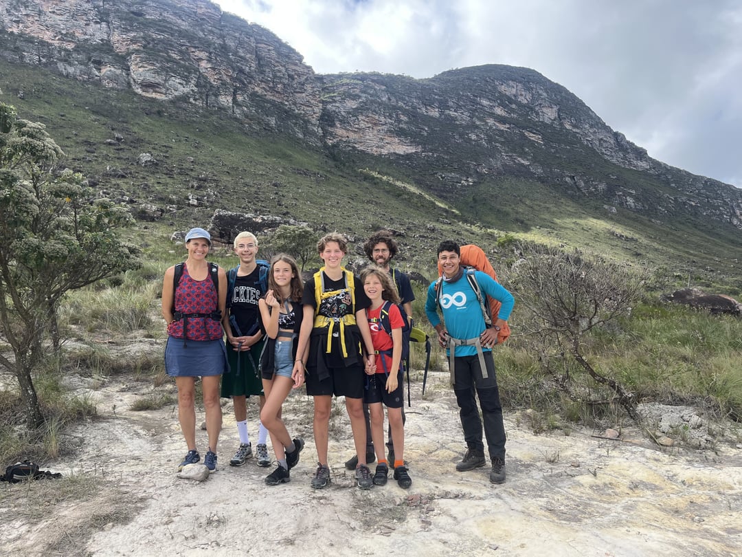 Excursionista haciendo una pausa en un sendero rodeado por las montañas del Vale do Pati