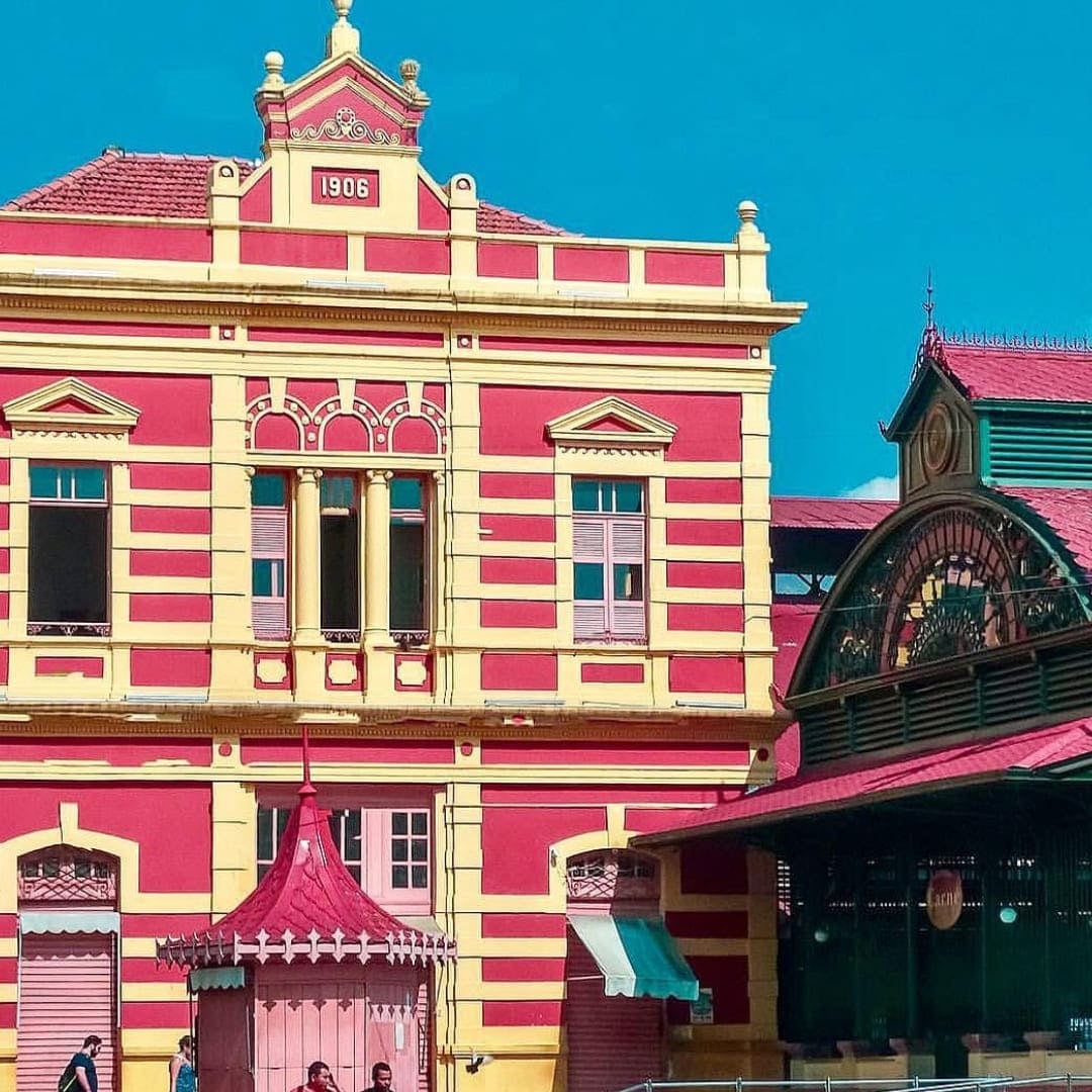 Historic red and pink colonial building facade in Manaus featuring architecture from the rubber boom era.