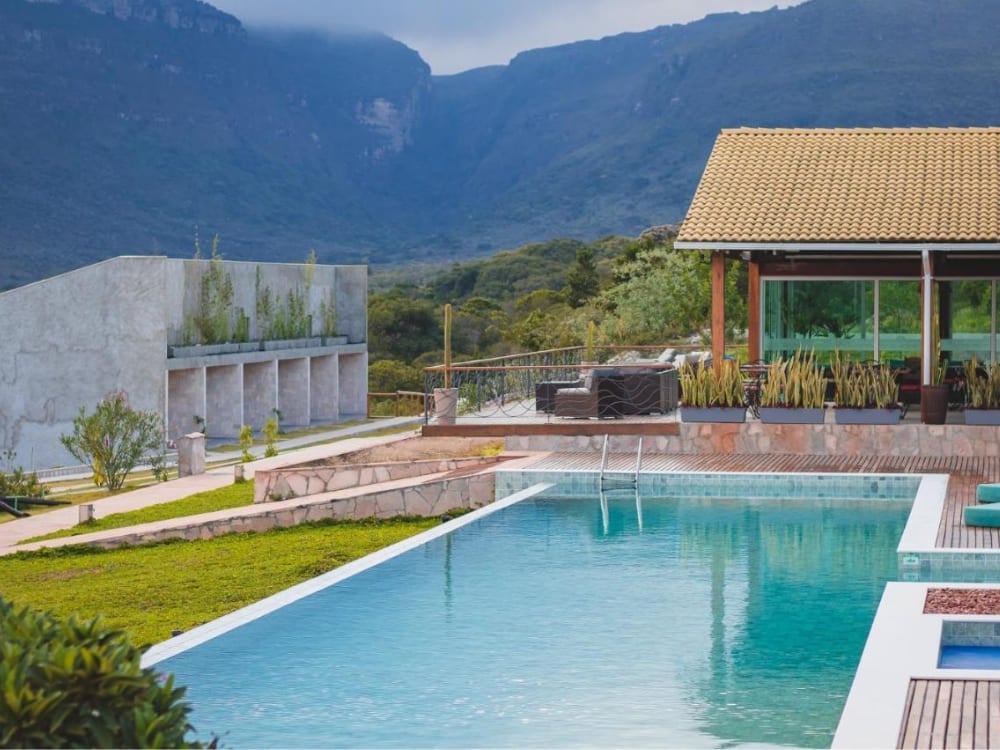 Modern swimming pool and sophisticated concrete architecture of Pousada Amanhecer overlooking the mountains in Vale do Capão. 