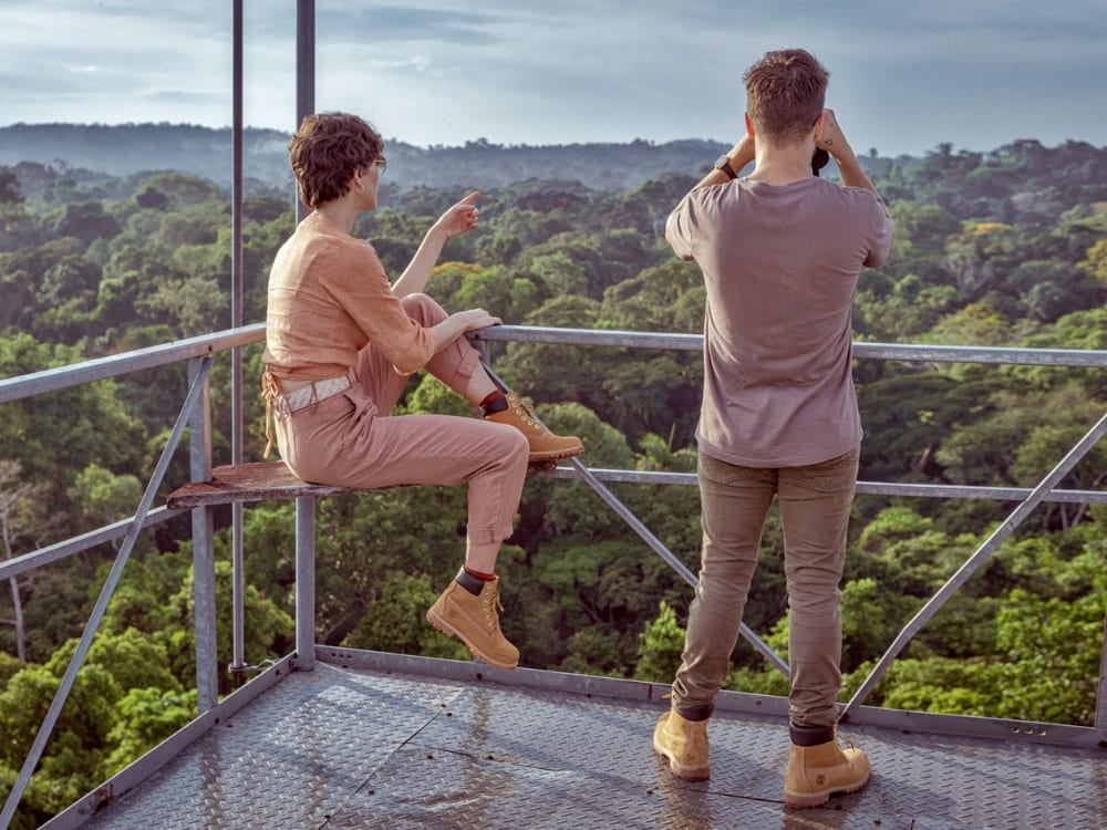 Voyageurs utilisant des jumelles sur une tour d'observation haut au-dessus de la canopée pour repérer en toute sécurité les oiseaux et la faune dans la forêt amazonienne.