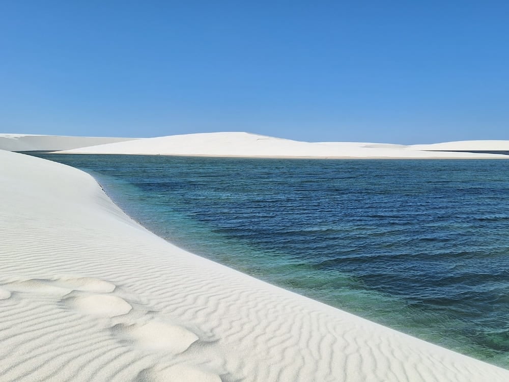 Turquoise zoetwaterlagunes genesteld tussen uitgestrekte witte zandduinen in Nationaal Park Lençóis Maranhenses.