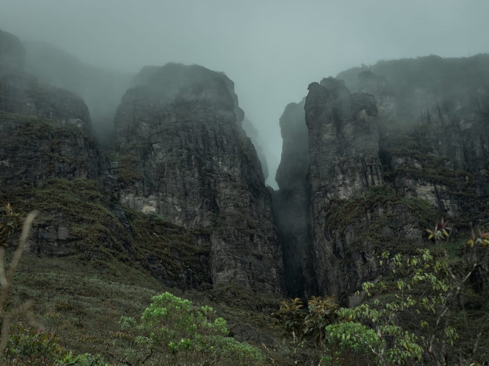 De donkere, rotsachtige kliffen van Pico da Neblina, de hoogste piek van Brazilië, gehuld in mist in het Amazonewoud.