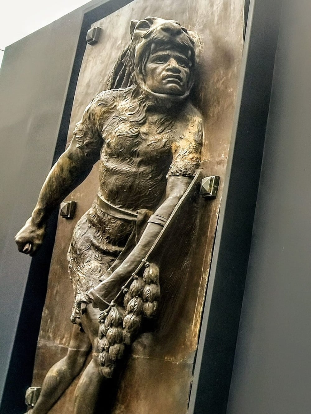 Um relevo de bronze de Jesús Fructuoso Contreras retratando Cacamatzin usando pele de onça como um guerreiro.