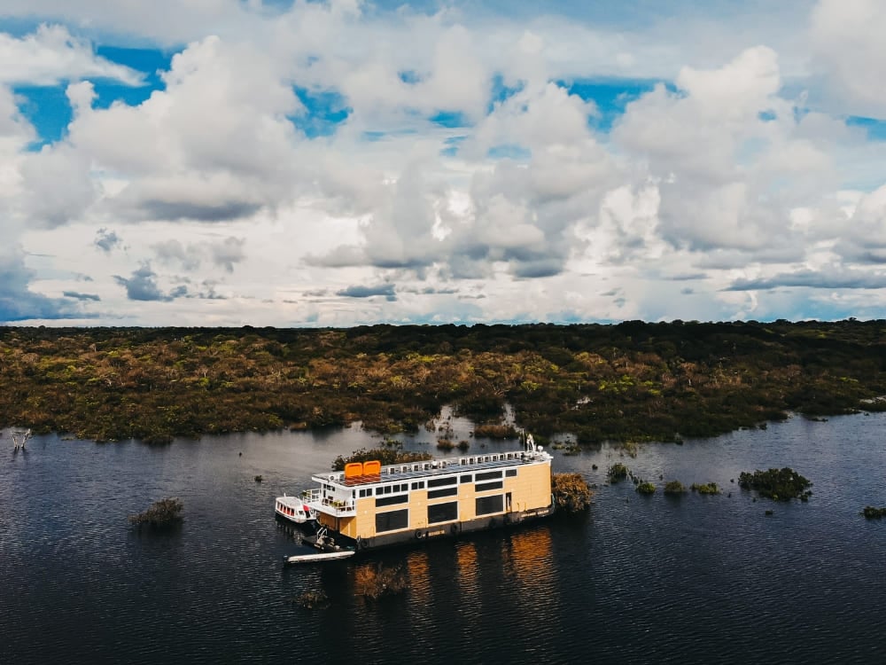Luftaufnahme des Luxus-Flussschiffs Untamed, das im Rio Negro inmitten des überfluteten Amazonas-Regenwaldes ankert.