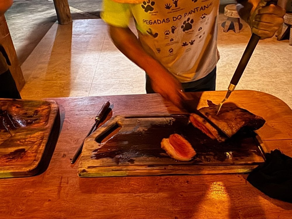 Lodge cook slicing grilled beef on a wooden board