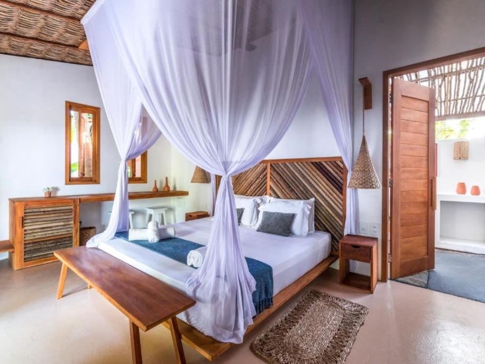 Elegant en licht interieur van een chalet in herberg Muita Paz, met de nadruk op een tweepersoonsbed bedekt met een grote doorschijnende klamboe. Elegant en licht interieur van een chalet in herberg Muita Paz, met de nadruk op een tweepersoonsbed bedekt met een grote doorschijnende klamboe.