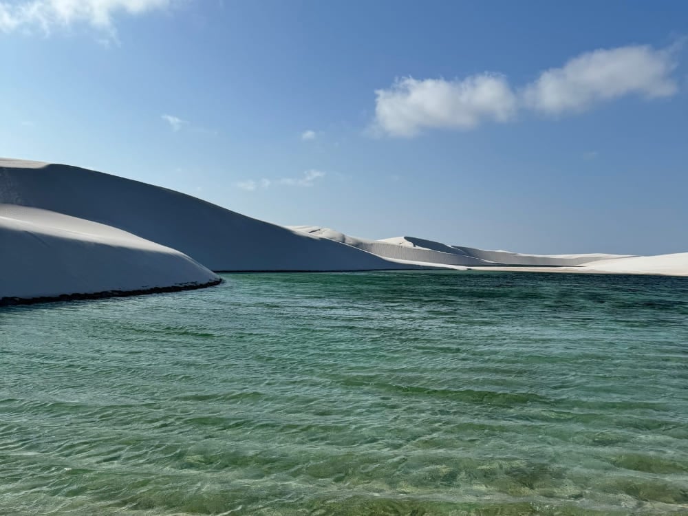 Extensas dunas de areia branca encontram uma lagoa verde cristalina sazonal no Parque Nacional dos Lençóis Maranhenses. Extensas dunas de areia branca encontram uma lagoa verde cristalina sazonal no Parque Nacional dos Lençóis Maranhenses.