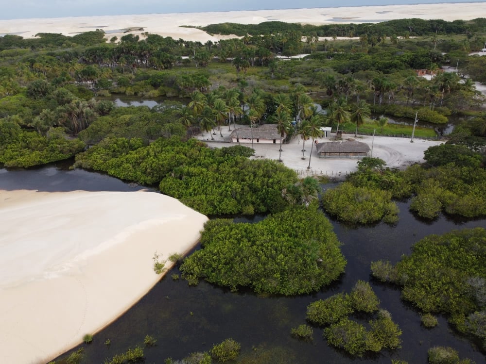 Pequenas casas cercadas por exuberante vegetação nativa e dunas de areia inativas nos Lençóis Maranhenses. Pequenas casas cercadas por exuberante vegetação nativa e dunas de areia inativas nos Lençóis Maranhenses.