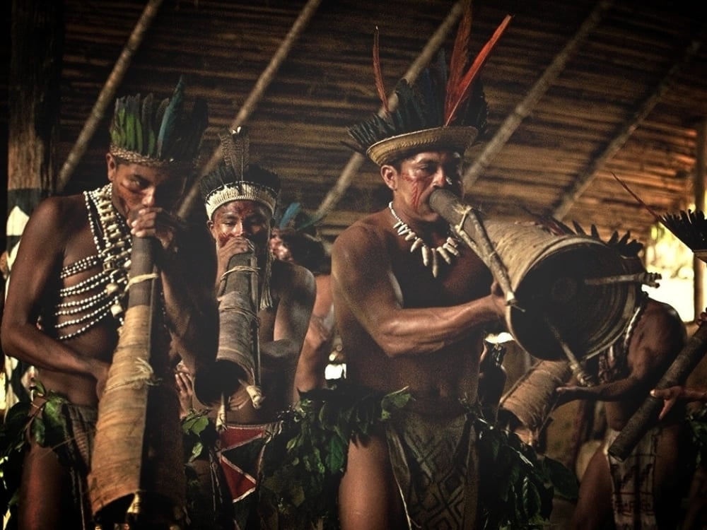 Indigene Männer spielen während einer kulturellen Zeremonie im Amazonas traditionelle Blasinstrumente. Indigene Männer spielen während einer kulturellen Zeremonie im Amazonas traditionelle Blasinstrumente.