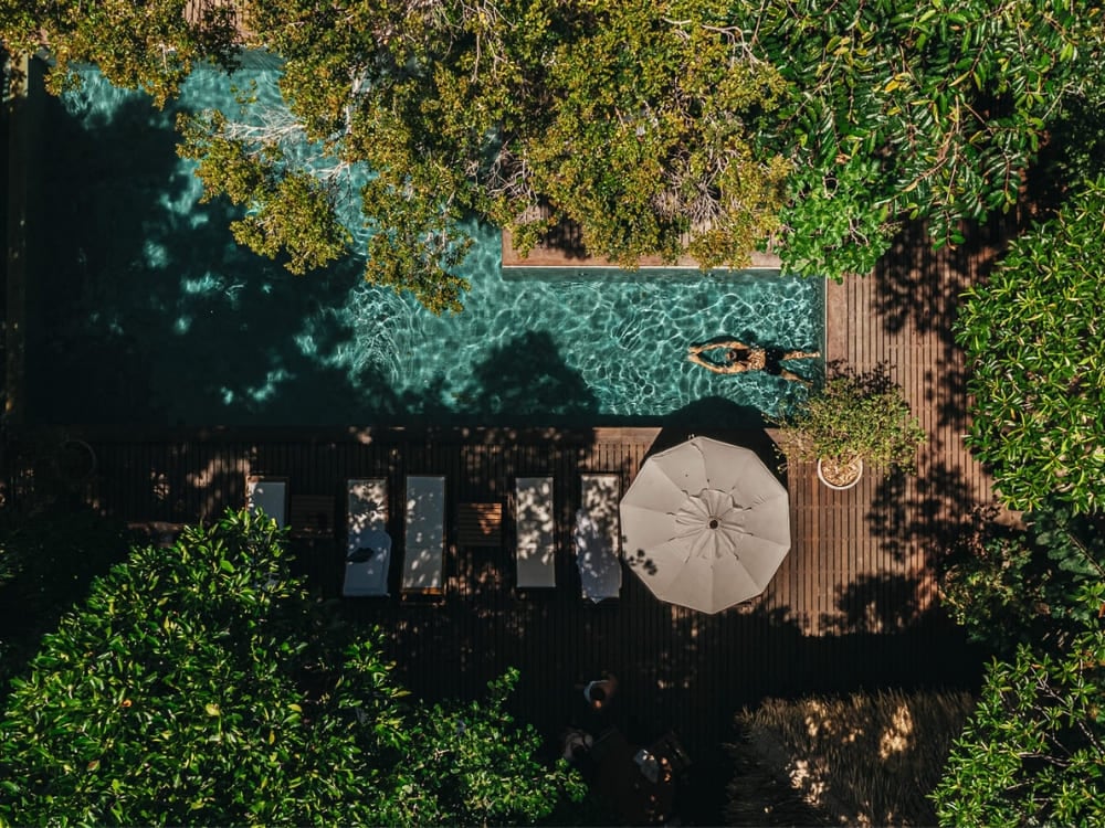 Vista aérea de uma piscina em um eco-lodge de luxo aninhado nas profundezas da vegetação da Floresta Amazônica, oferecendo lazer na natureza. Vista aérea de uma piscina em um eco-lodge de luxo aninhado nas profundezas da vegetação da Floresta Amazônica, oferecendo lazer na natureza.