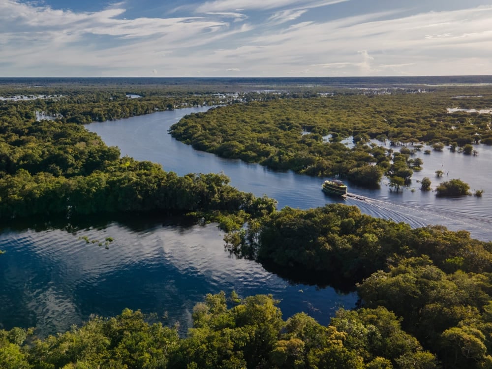 Un bateau de rivière naviguant dans un canal sinueux de la forêt amazonienne, parfait pour une croisière sur l'Amazone. Un bateau de rivière naviguant dans un canal sinueux de la forêt amazonienne, parfait pour une croisière sur l'Amazone.