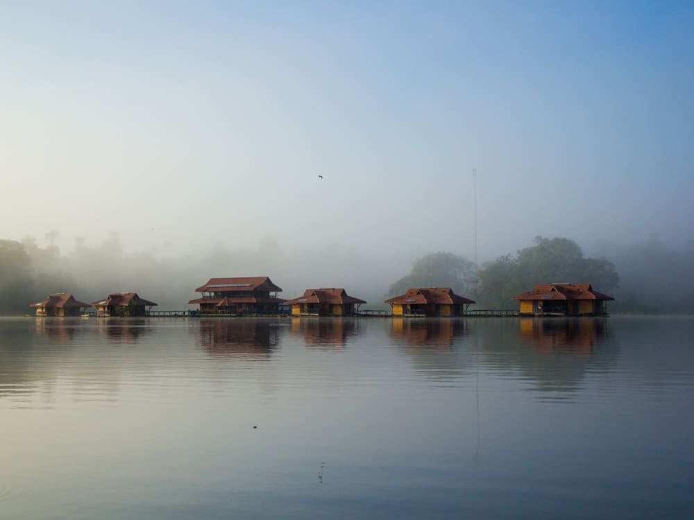 Das schwimmende Uakari-Lodge-Hotel aus Holzhütten auf den ruhigen Gewässern des Mamirauá-Sees mit Nebel im Hintergrund. Das schwimmende Uakari-Lodge-Hotel aus Holzhütten auf den ruhigen Gewässern des Mamirauá-Sees mit Nebel im Hintergrund.