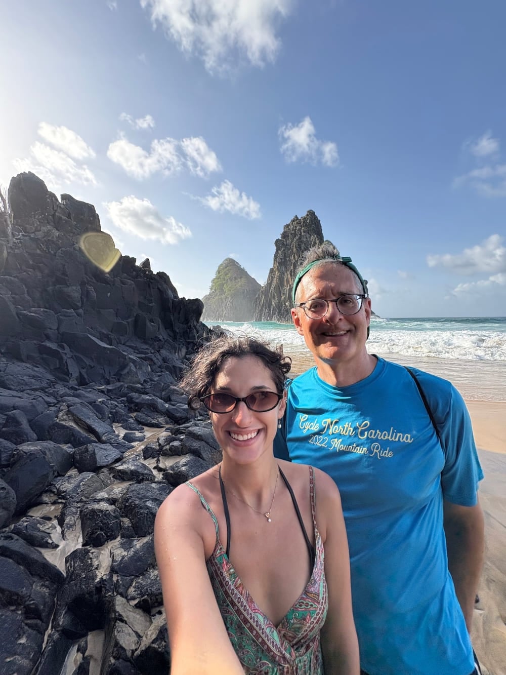 Vater und Tochter machen ein Selfie an einem felsigen Strand mit den Felsformationen Morro Dois Irmãos und dem Ozean im Hintergrund. Vater und Tochter machen ein Selfie an einem felsigen Strand mit den Felsformationen Morro Dois Irmãos und dem Ozean im Hintergrund.