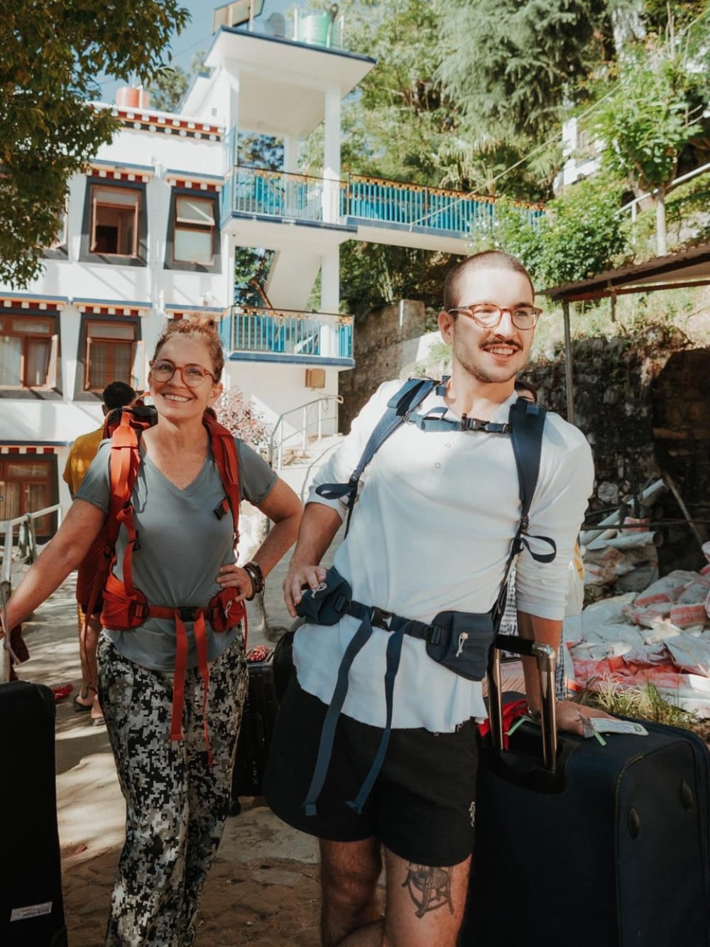 Mila en Lorenzo dragen trekkingrugzakken en glimlachen terwijl ze zich voorbereiden op de fysieke uitdaging van de Mardi Himal trek in Nepal. Mila en Lorenzo dragen trekkingrugzakken en glimlachen terwijl ze zich voorbereiden op de fysieke uitdaging van de Mardi Himal trek in Nepal.