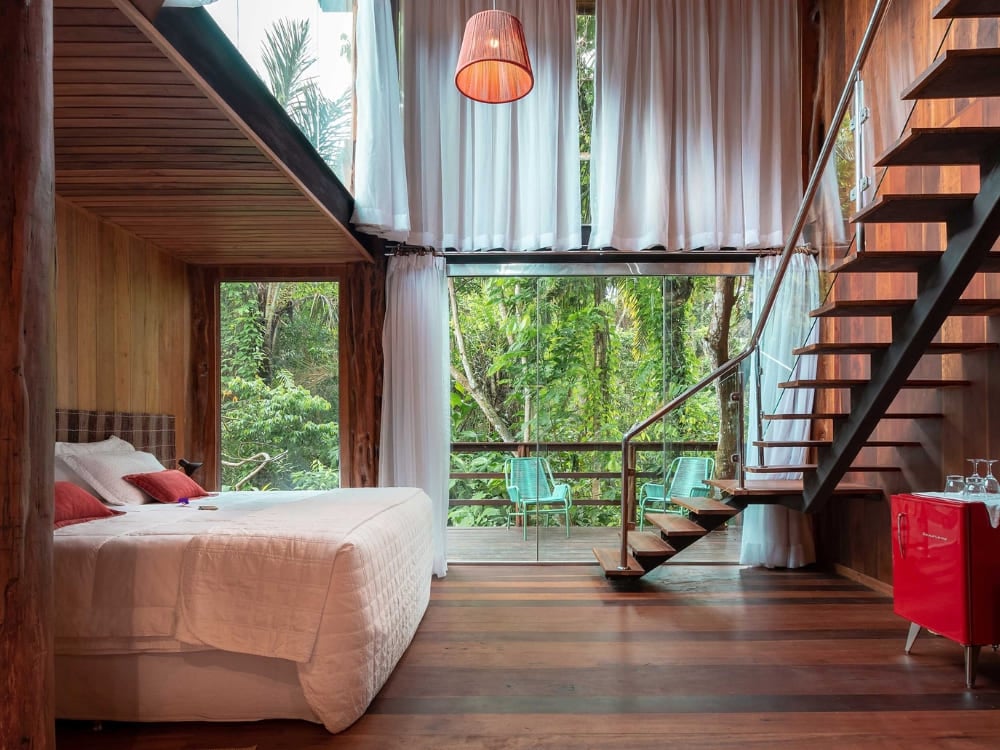 Um quarto de luxo com uma grande janela de vidro de frente para a floresta no Mirante do Gavião, na floresta amazônica. Um quarto de luxo com uma grande janela de vidro de frente para a floresta no Mirante do Gavião, na floresta amazônica.