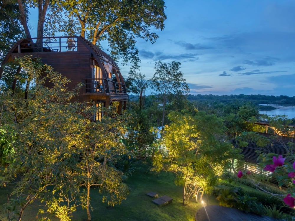 A arquitetura de madeira única do lodge Mirante do Gavião iluminada ao entardecer, representando um dos melhores lodges de selva da Amazônia no Brasil. A arquitetura de madeira única do lodge Mirante do Gavião iluminada ao entardecer, representando um dos melhores lodges de selva da Amazônia no Brasil.