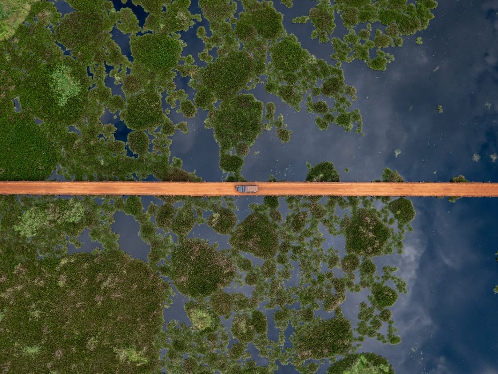 Vue aérienne d'un chemin de terre droit coupant à travers le paysage vert inondé du Pantanal. Vue aérienne d'un chemin de terre droit coupant à travers le paysage vert inondé du Pantanal.