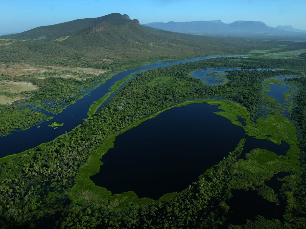 Vue aérienne d'une rivière bleu profond serpentant à travers les vastes plaines vertes de la région du Pantanal. Vue aérienne d'une rivière bleu profond serpentant à travers les vastes plaines vertes de la région du Pantanal.