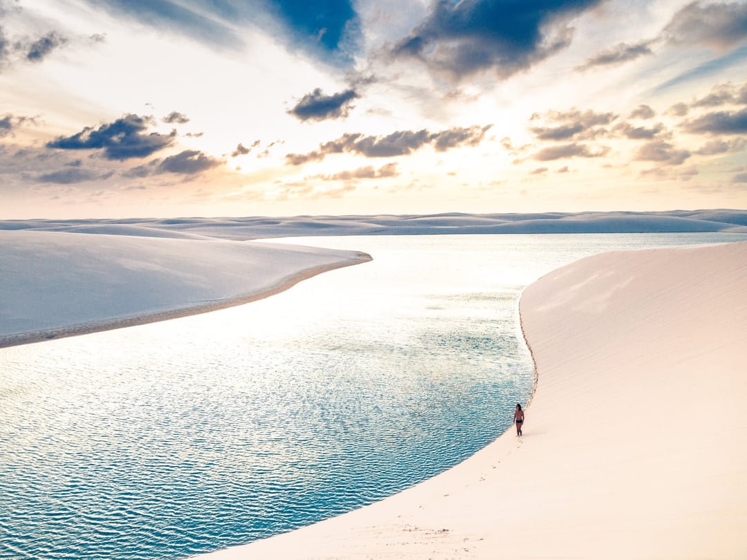 Wanderer durchqueren die weißen Dünen und Süßwasserlagunen der Lençóis Maranhenses Wanderer durchqueren die weißen Dünen und Süßwasserlagunen der Lençóis Maranhenses