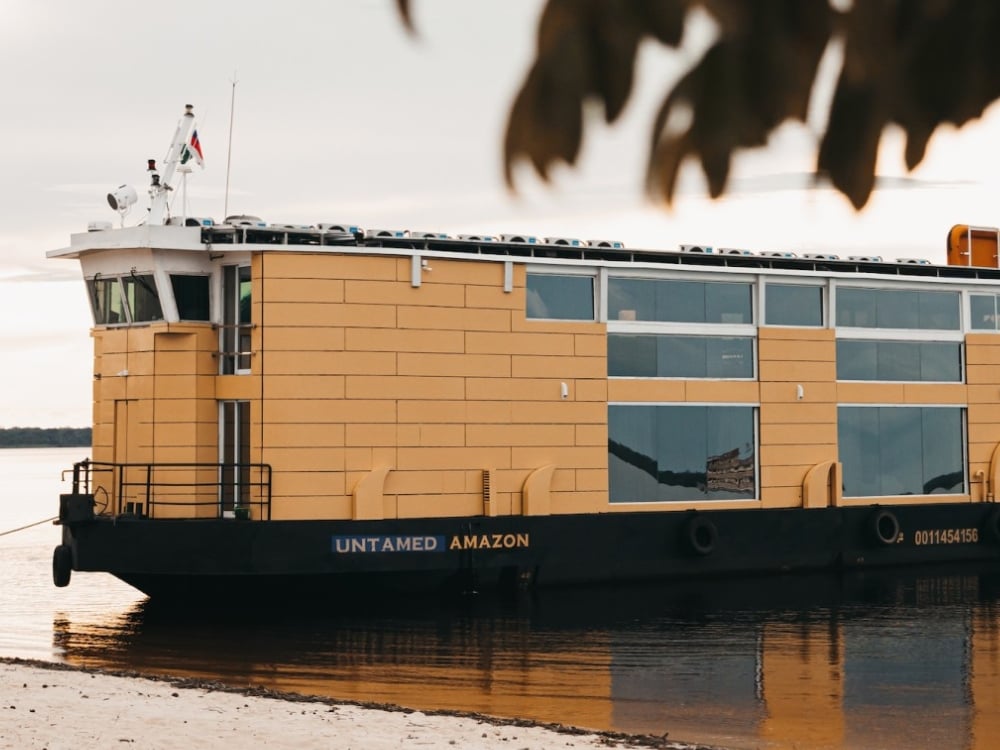 Le bateau Untamed Amazon au design moderne avec une coque jaune, connu pour être une option de croisière durable alimentée à l'énergie solaire. Le bateau Untamed Amazon au design moderne avec une coque jaune, connu pour être une option de croisière durable alimentée à l'énergie solaire.