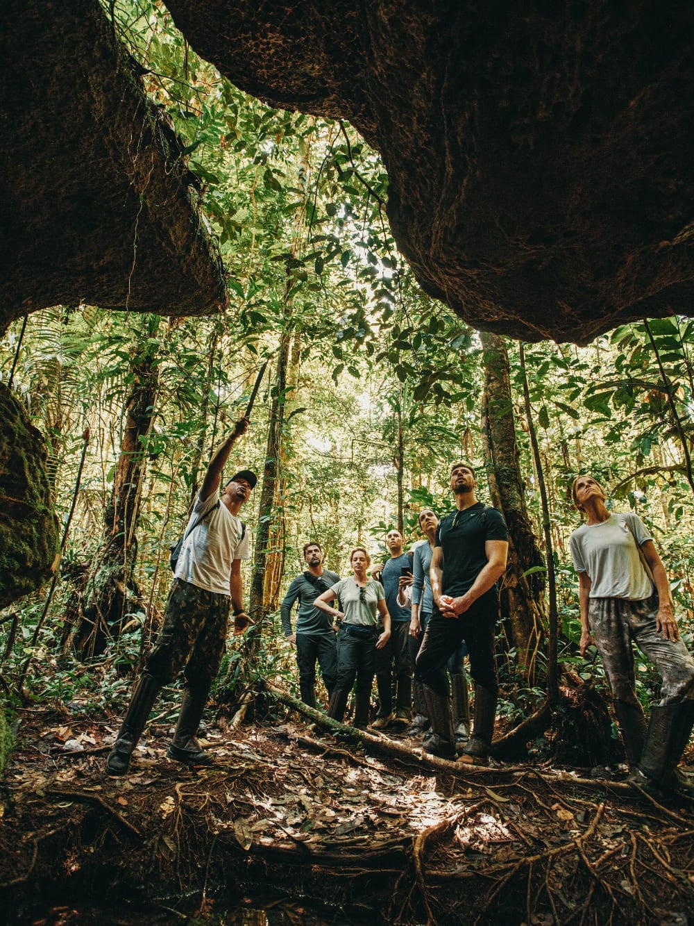 Groupe de touristes explorant une formation rocheuse au sein de la forêt amazonienne, regardant la jungle avec un guide local expert. Groupe de touristes explorant une formation rocheuse au sein de la forêt amazonienne, regardant la jungle avec un guide local expert.