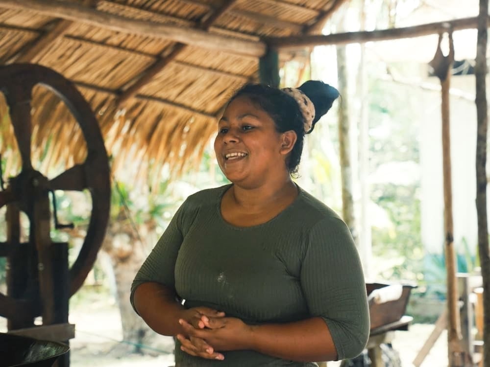 Mulher sorridente de uma comunidade ribeirinha da Amazônia em pé sob um telhado tradicional de palha. Mulher sorridente de uma comunidade ribeirinha da Amazônia em pé sob um telhado tradicional de palha.