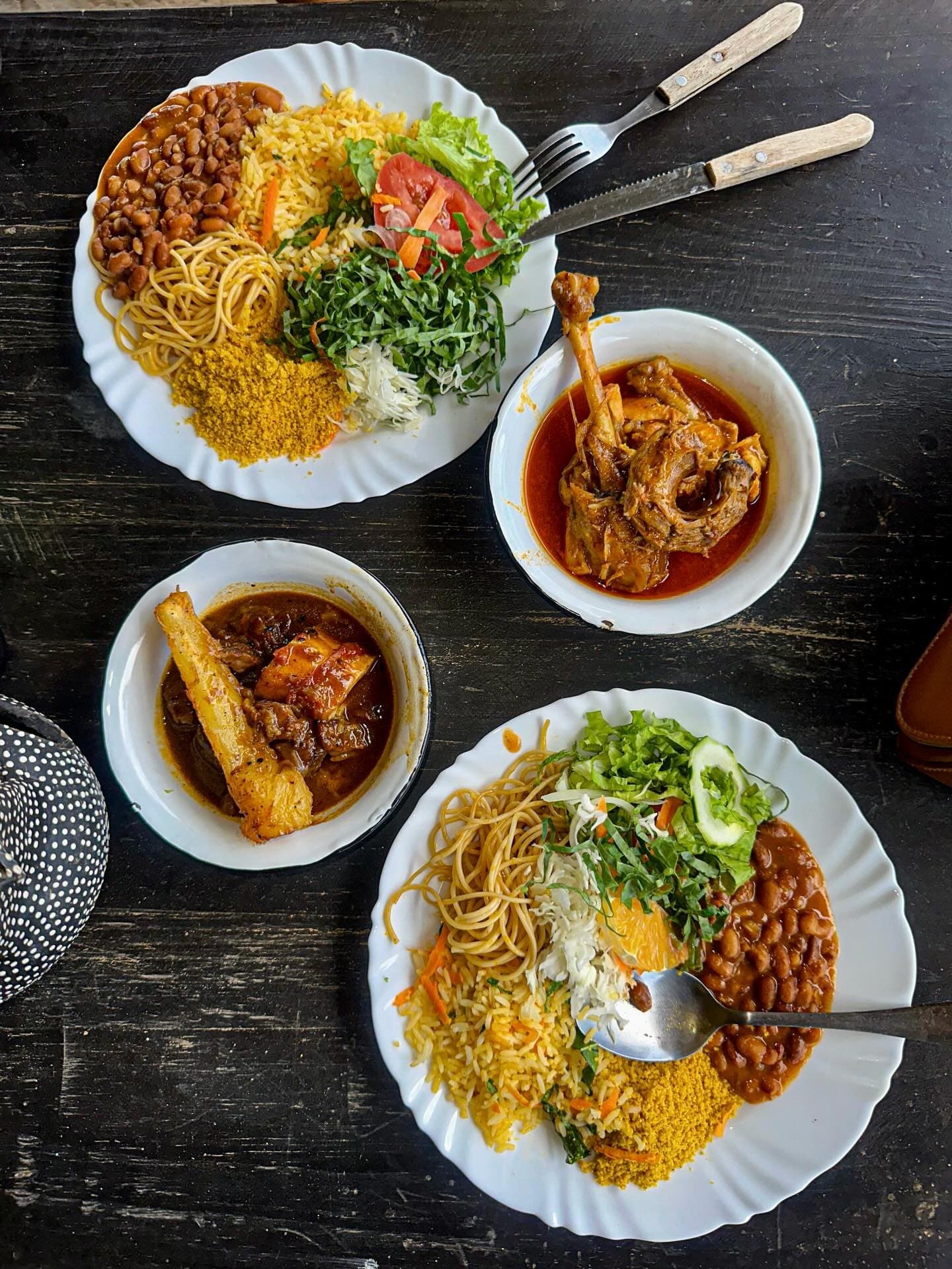 Le genre de repas qui vous retient à table bien après la fin. Vue de dessus de deux grandes assiettes garnies de riz, farofa, nouilles, haricots et salade fraîche, accompagnées de deux bols de viande braisée en sauce, servies dans un restaurant local près de Lençóis Maranhenses Santo Amaro
