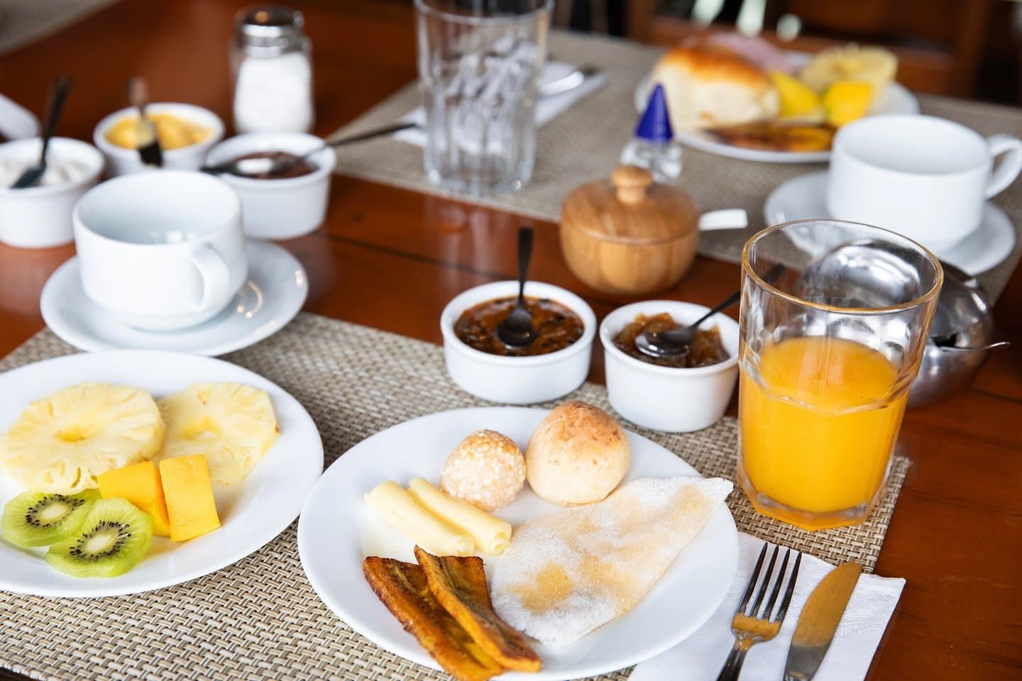 Ein gutes Frühstück, bevor der Fluss wieder ruft. Reichhaltiges Frühstückstisch auf einem Amazonas-Jungle-Kreuzfahrtschiff in Brasilien: frische Ananas, Kiwi und Mango, Käsebrötchen, gebratene Kochbananen, eine Tapioca-Crêpe, Fruchtaufstriche und Orangensaft