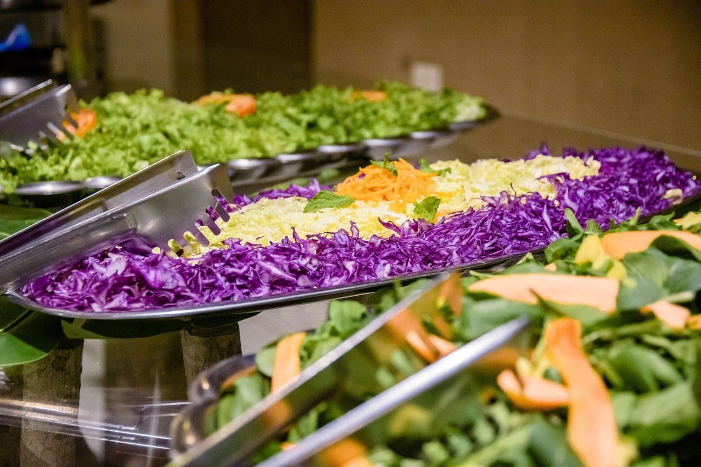 Frische Farben auf dem Teller, bevor es in die Natur geht. Ein Buffet auf einer günstigen Pantanal-Tour mit geriebenem Rot- und Weißkohl, geraspelter Karotte, frischem Spinat und Melonenscheiben in großen Edelstahlschalen
