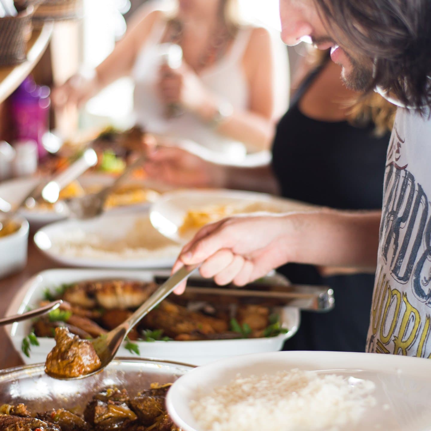 Les plats passent de main en main, et personne ne regarde l'heure. Des voyageurs se servent à un buffet de viande braisée et de poisson grillé lors d'une croisière fluviale sur l'Amazone au Brésil