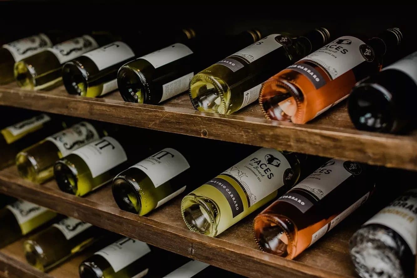 Adega farta, jantar garantido. Merecia, depois do dia que foi. Garrafas de Chardonnay e rosé Lidio Carraro Faces do Brasil repousando em adegas de madeira, parte da experiência gastronômica de um passeio de ciclismo na Bahia