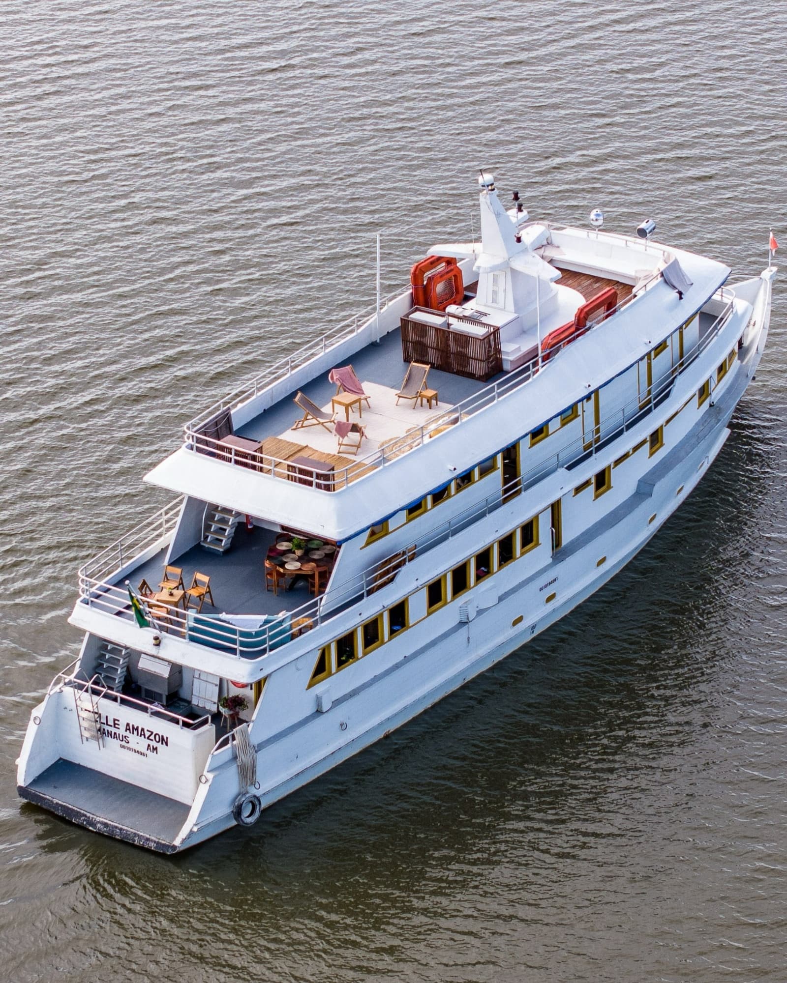 Votre base flottante sur le fleuve, vue depuis les hauteurs. Vue aérienne du bateau de croisière fluviale Belle Amazon navigant sur le fleuve Amazone, avec terrasses ensoleillées et mobilier de détente sur trois niveaux