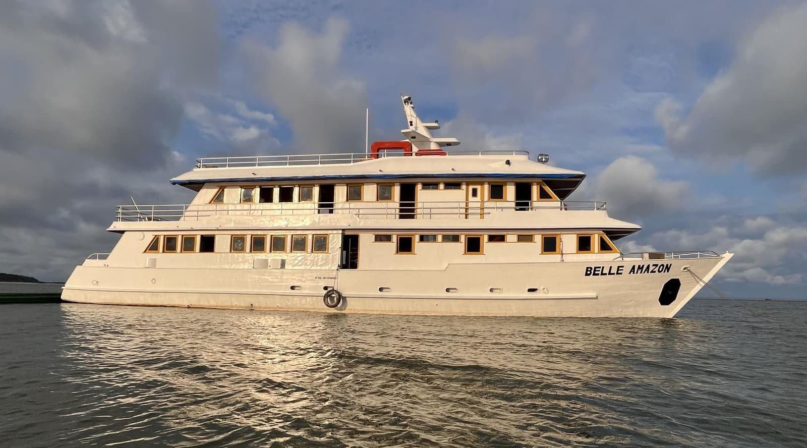 Votre maison flottante pour les prochains jours. On a connu pire. Le navire de croisière fluviale Belle Amazon à plusieurs ponts ancré sur des eaux calmes sous un ciel nuageux