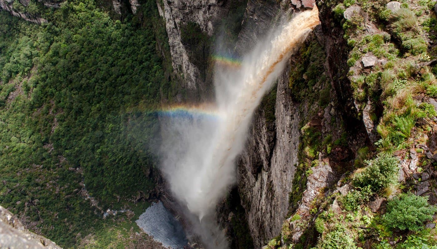 A double rainbow caught mid-plunge — mist, colour and raw vertical drop all at once. Photo 1