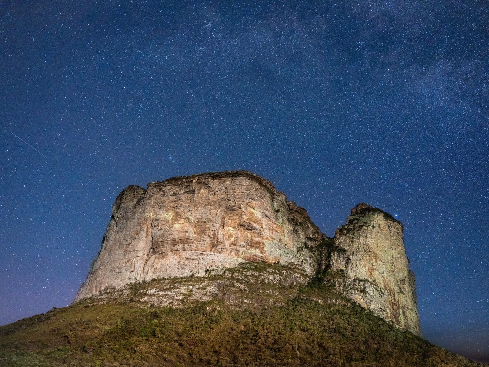 Ancient rock, infinite sky — the Milky Way arches over sculpted sandstone cliffs. Photo 5