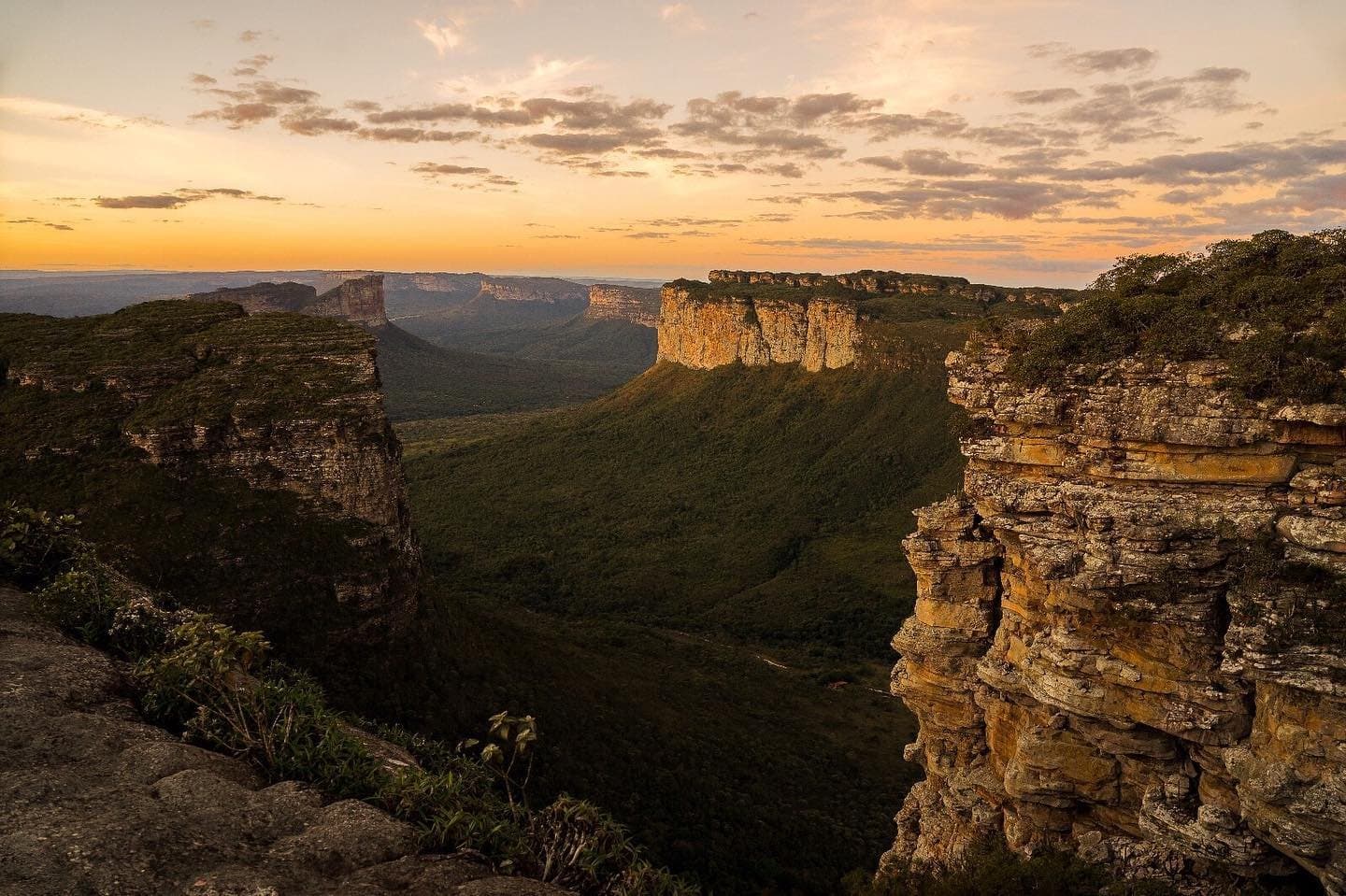 Amber light ignites the clifftops as the valley sinks into shadow. Photo 4