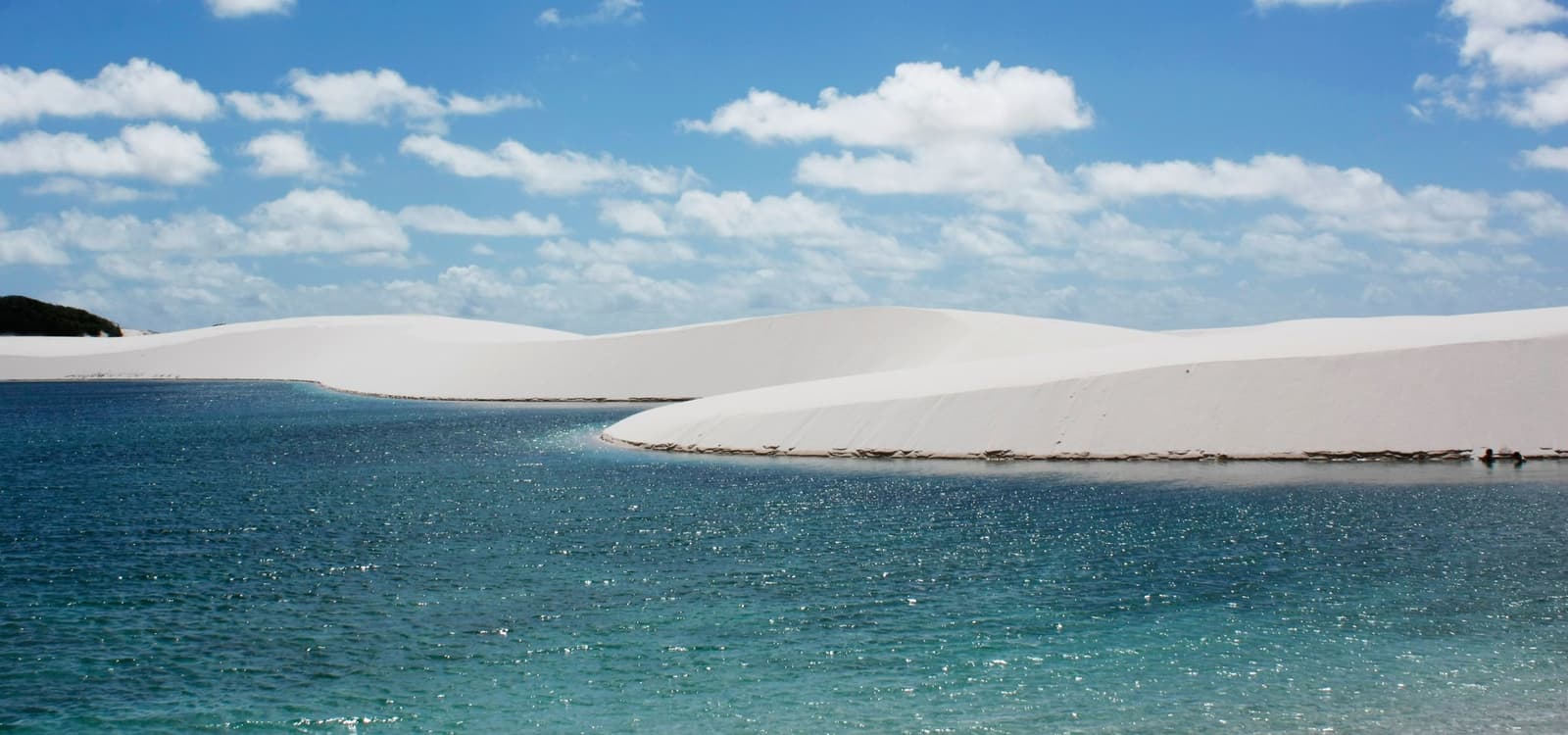 Du sable, de l'eau, et un paysage qu'on n'attendait pas du tout. Lagune aux eaux cristallines et ciel lumineux reflété entre les dunes de sable blanc — paysage emblématique du circuit à cheval dans les Lençóis Maranhenses