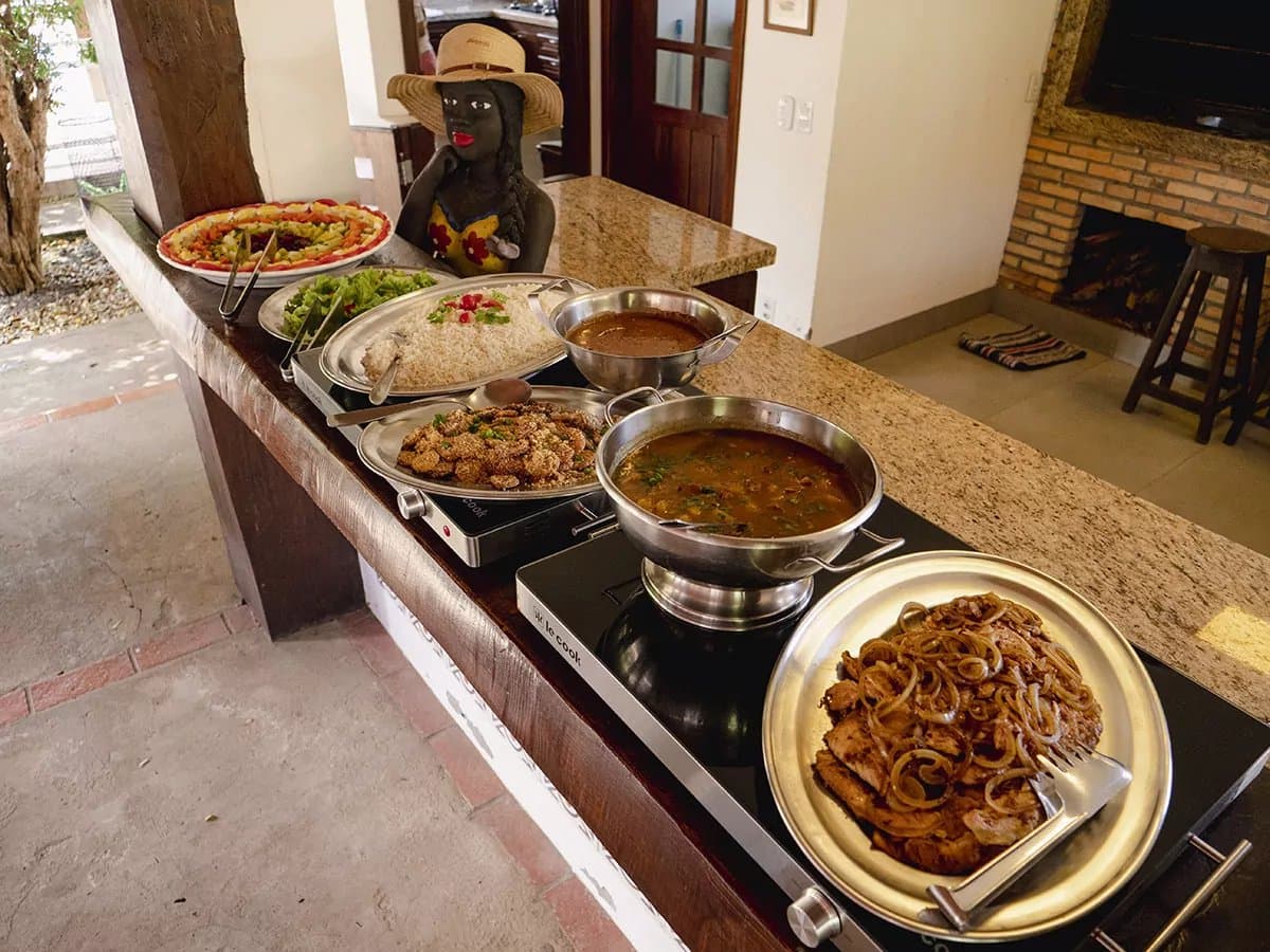 Nach einem Morgen im Gelände schmeckt das Mittagessen gleich doppelt gut. Eine mit Granitplatte ausgestattete Buffettheke mit dampfenden Schmorgerichten, gewürztem Fleisch mit karamellisierten Zwiebeln, Reis, frittierten Happen, Salaten und einem bunten Obstkorb – herzhafte brasilianische Lodgeküche auf einer Pantanal-Bonito-Tour