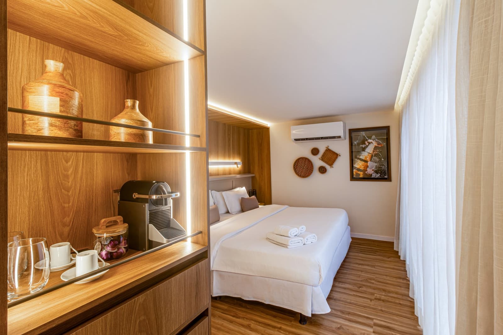 Koffie klaarstaan voordat jij er zelfs aan denkt. Photo: STUDIO CREATE Een verzorgde hut aan boord van een luxe Amazonecruise in Brazilië, met een tweepersoonsbed met frisse witte lakens en gevouwen handdoeken, een verlichte houten wandkast met een capsulekoffiemachine, keramieken kopjes, decoratieve aardewerken vazen, gevlochten manden aan de muur en doorschijnende gordijnen