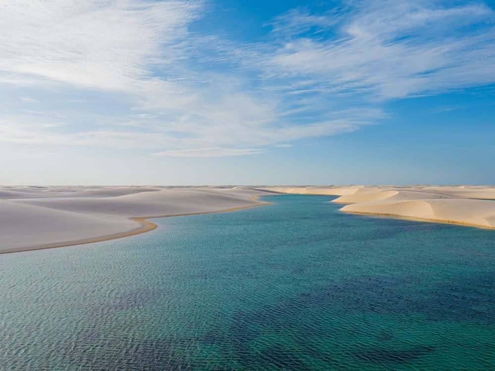 Türkisfarbene Lagune zwischen den weißen Sanddünen der Lençóis Maranhenses unter blauem Himmel. Türkisfarbene Lagune zwischen den weißen Sanddünen der Lençóis Maranhenses unter blauem Himmel.