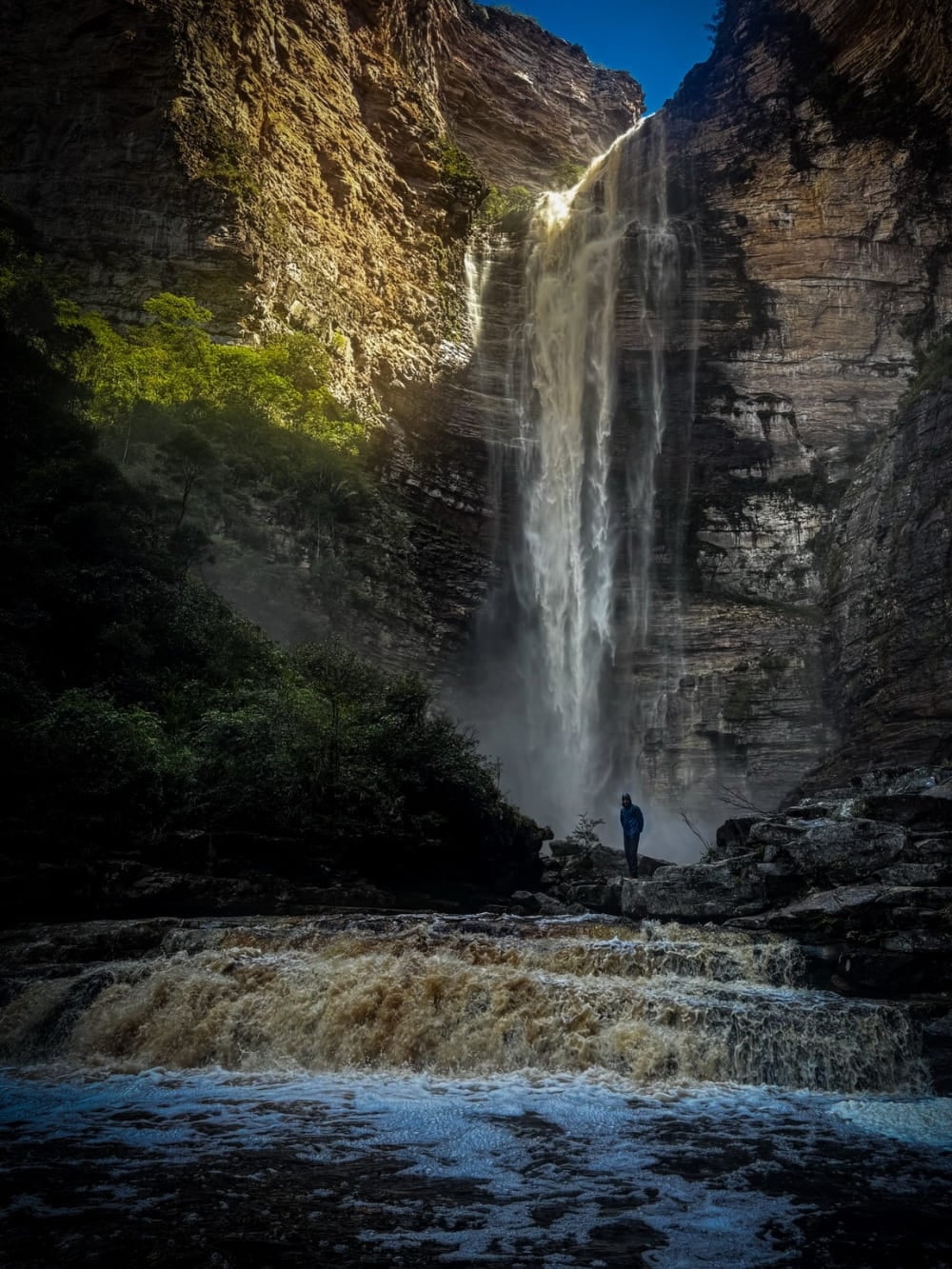 Un escursionista solo alla base della Cachoeira da Encantada, che cade fra le pareti del canyon sopra le acque ambrate del Rio Samina, nella Chapada Diamantina, in Brasile. Un escursionista solo alla base della Cachoeira da Encantada, che cade fra le pareti del canyon sopra le acque ambrate del Rio Samina, nella Chapada Diamantina, in Brasile.