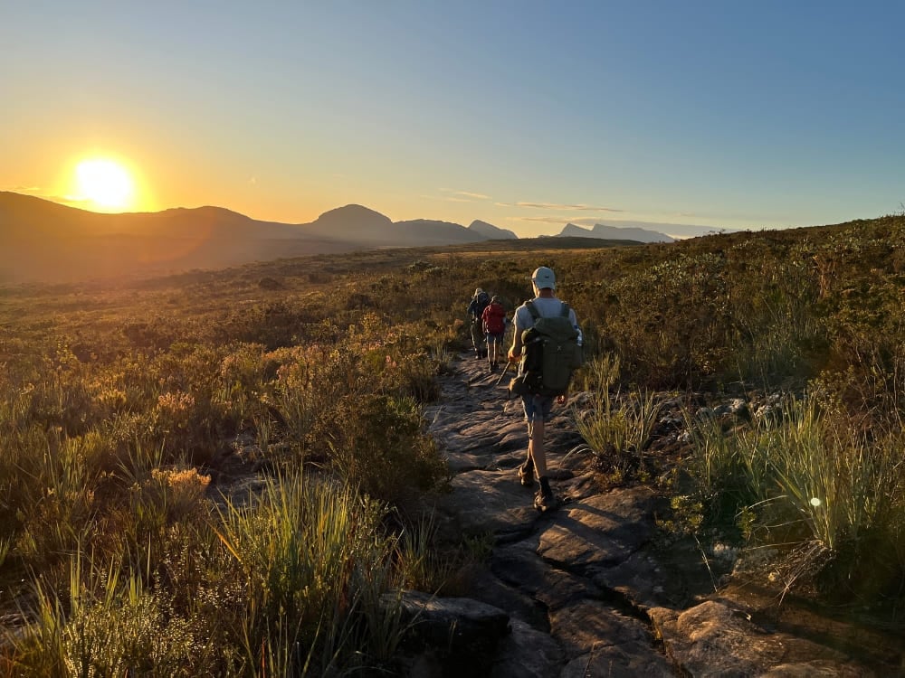 A group hiking a stone path at sunrise on the Vale do Pati trek in Chapada Diamantina, Brazil. A group hiking a stone path at sunrise on the Vale do Pati trek in Chapada Diamantina, Brazil.