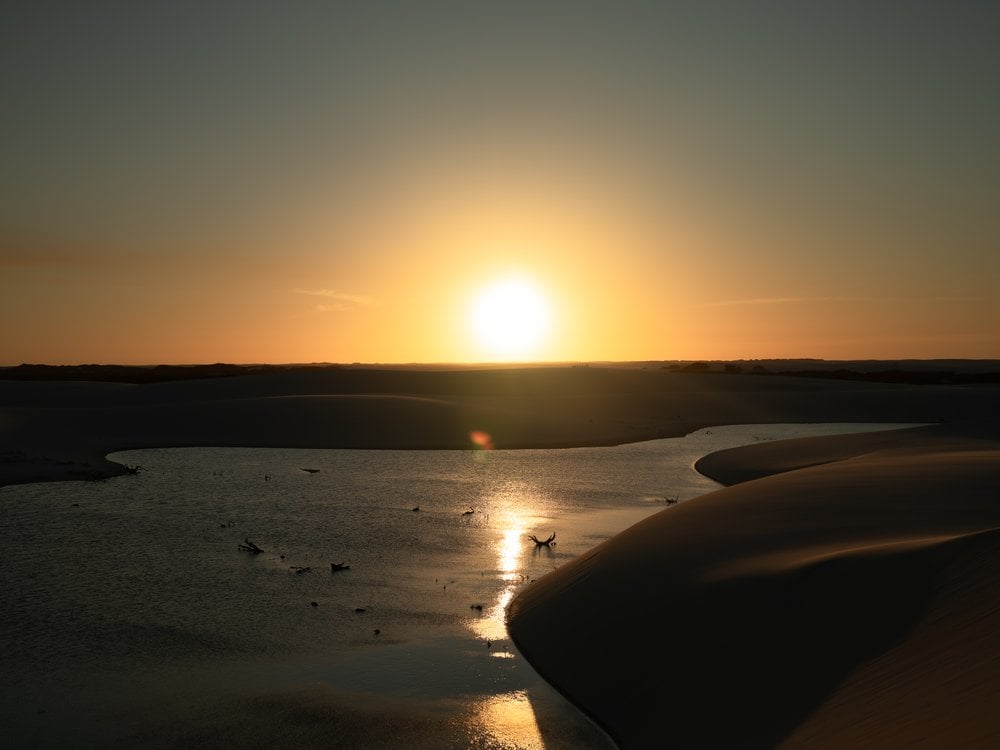 Far beyond the crowded lagoons: the spectacular scenery of the Lençóis Maranhenses, where low-impact tourism is transforming the lives of those who live in the park. (Credit: Isadora Sá) Sunset over a rainwater lagoon between the white dunes of Lençóis Maranhenses