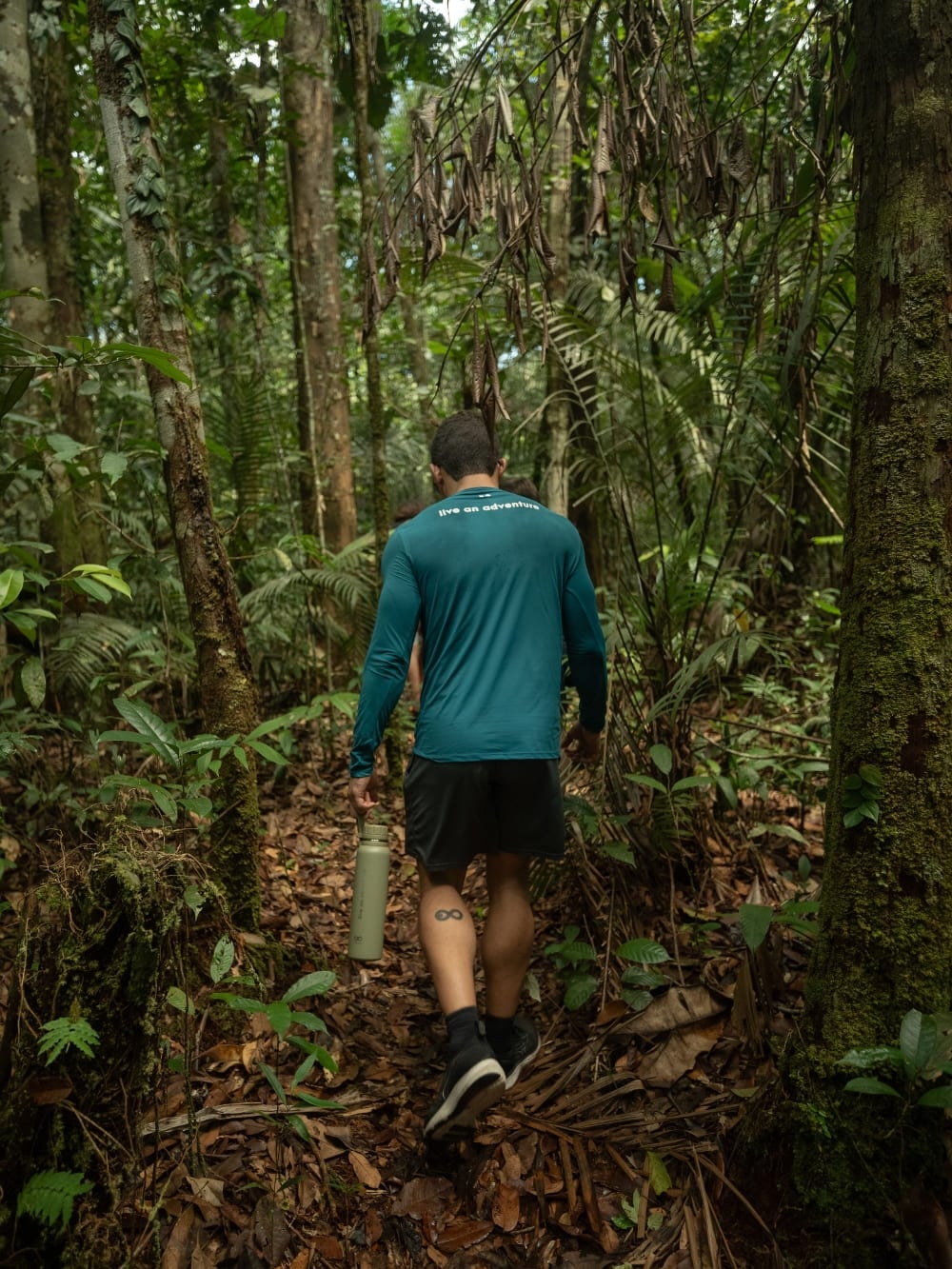 Photo: Marcelo Bonifácio Voyageur avec une gourde sur un sentier de jungle dans la forêt amazonienne, au Brésil
