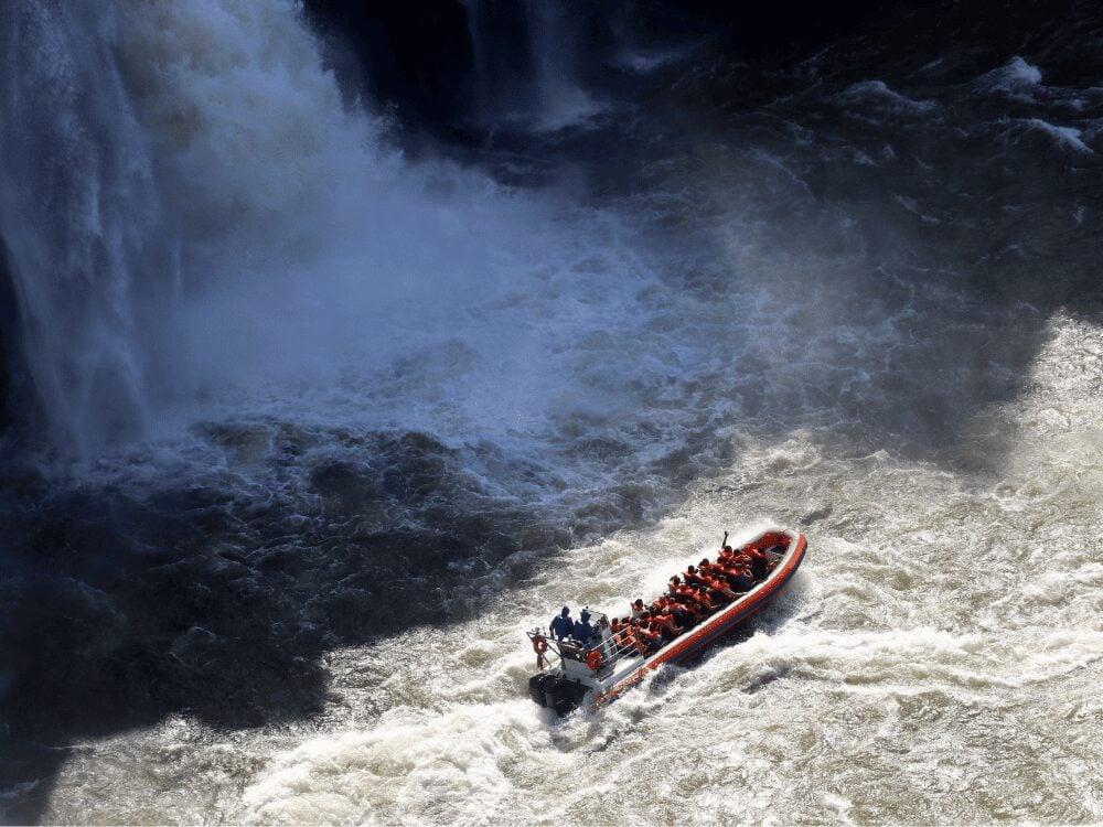 Photo: Christian Edelmann Boat tour with passengers in life jackets speeding toward the spray of Iguazu Falls