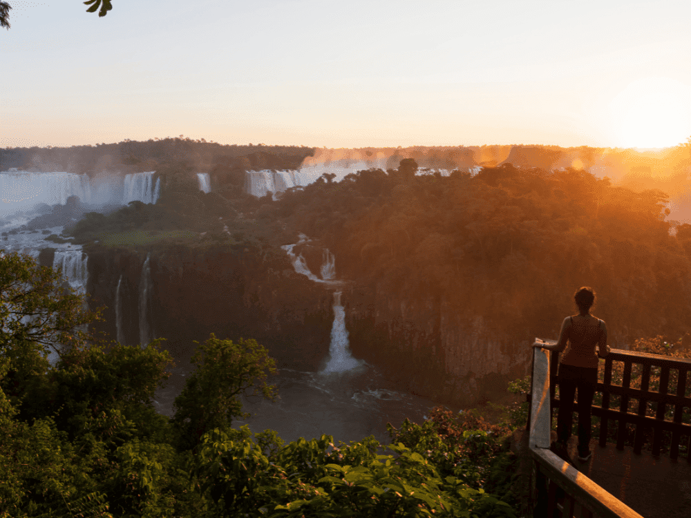 Photo: Joel Carillet Traveler watching the sunset over Iguazu Falls from a viewpoint