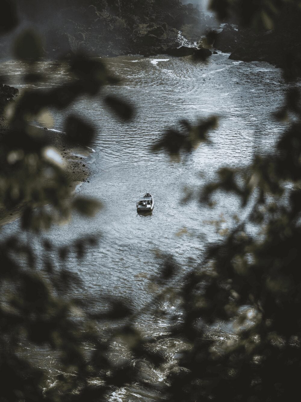 Photo: Fermin Rodriguez Penelas Small boat on the Iguazu River seen from above through the forest leaves