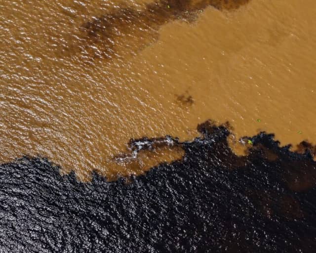 Aerial view of the Meeting of Waters near Manaus, where the dark Rio Negro meets the sandy-brown Solimões River Aerial view of the Meeting of Waters near Manaus, where the dark Rio Negro meets the sandy-brown Solimões River