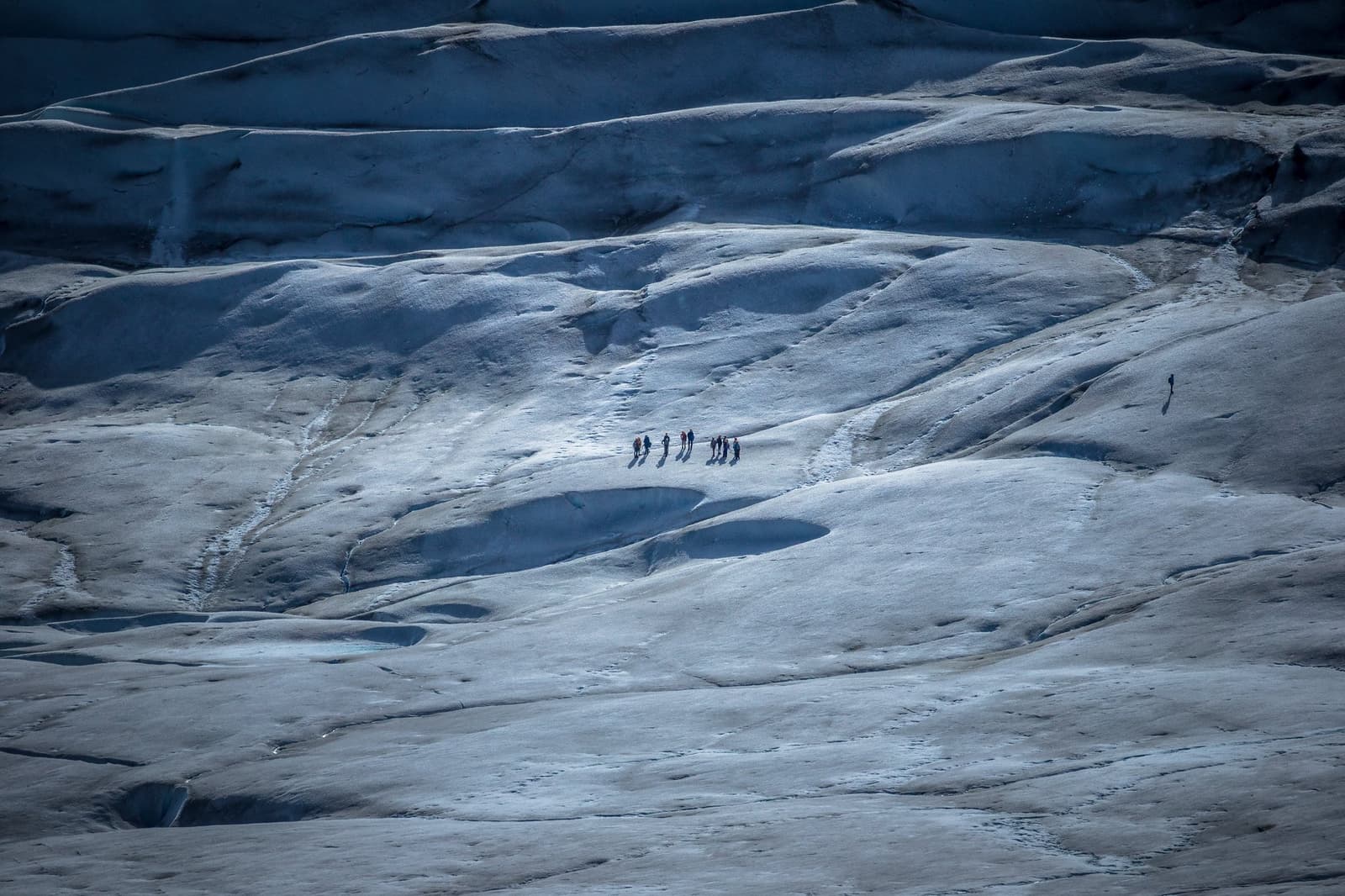 Six people, one glacier, and a very honest sense of scale. Photo: outdoorstv.cl A small group of trekkers crossing a vast blue-grey glacier surface on the self-guided O Circuit, dwarfed by rolling waves of ancient ice stretching in every direction
